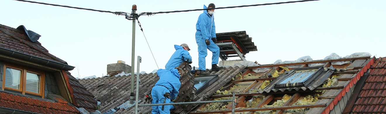 Dachdecker decken Dach mit Asbestfaserzementplatten ab für eine Dachsanierung in Fulda