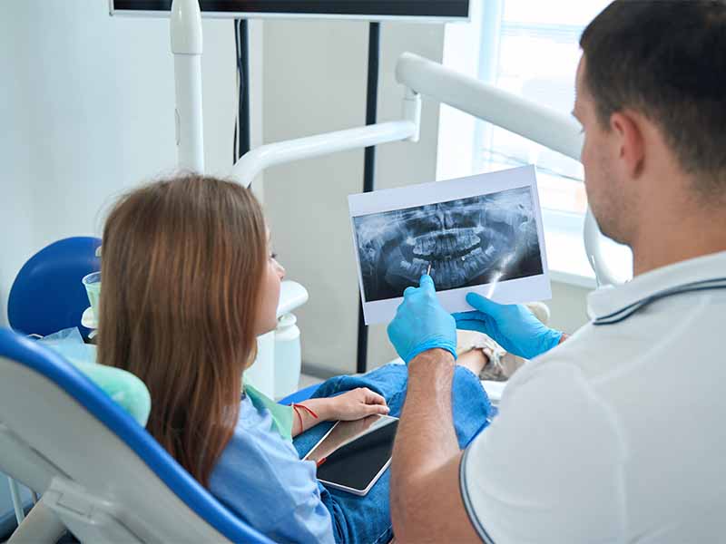 Ein Zahnarzt in Fulda erklärt einer Patientin die Vorteile eines Implantats in Fulda